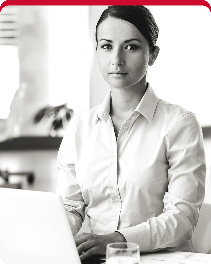 A woman in white shirt sitting on chair with laptop.