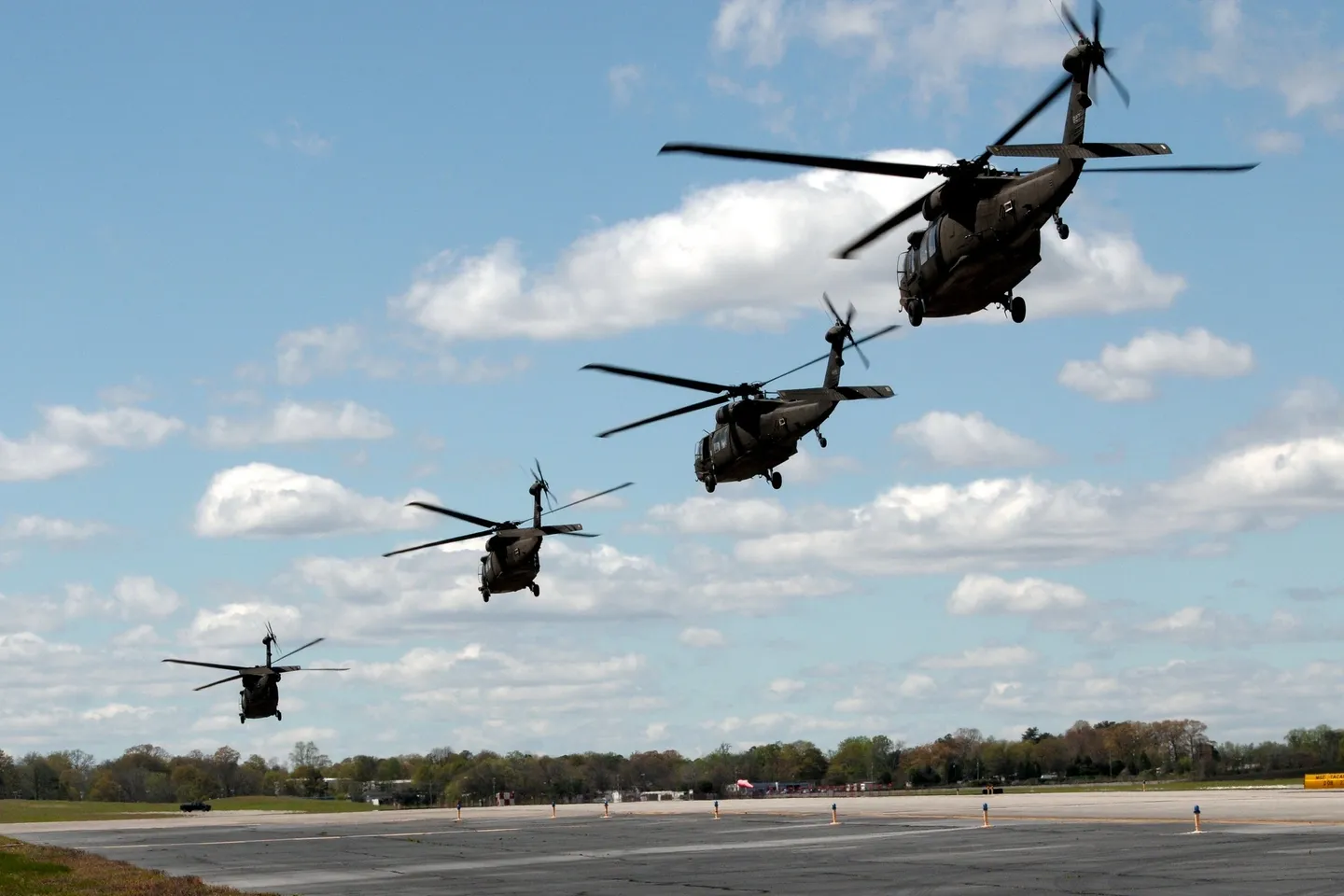 A group of black helicopters flying in the sky.